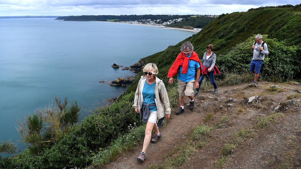 Hikers walk along the coast in France.