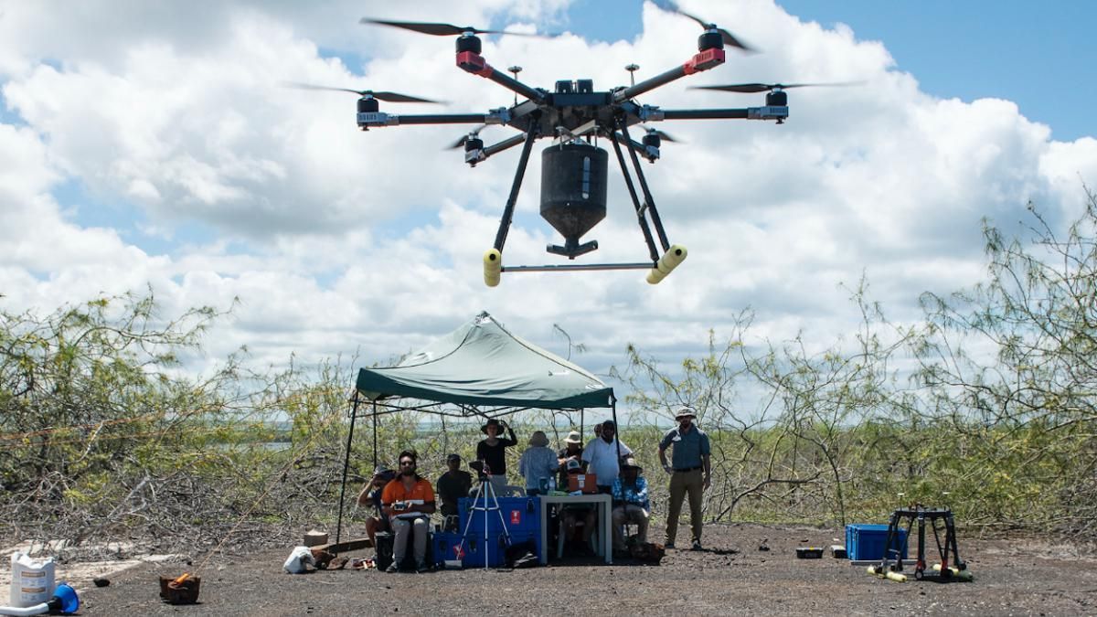 Scientists and drone pilots calibrate a drone before deploying it.