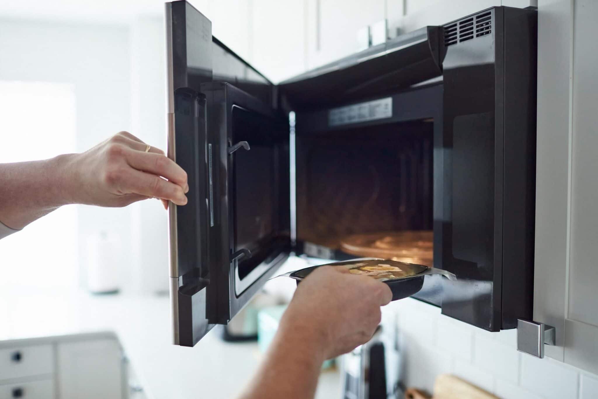 male putting food into a microwave