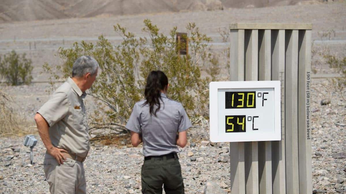 <wbr />Park staff take pictures of a thermometer display showing temperatures of 130° Fahrenheit in Death Valley, California.