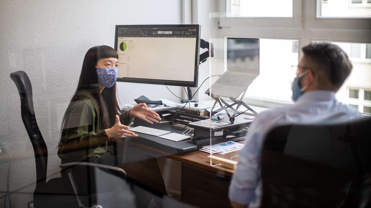 Two office workers wearing cotton face masks.