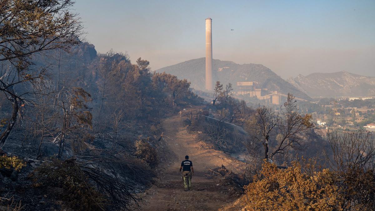 A firefigher walks on a dirt road toward a coal-fired power plant in Turkey.