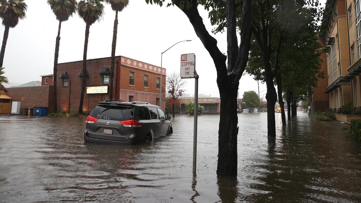 A minivan sits stranded on a flooded street in California.