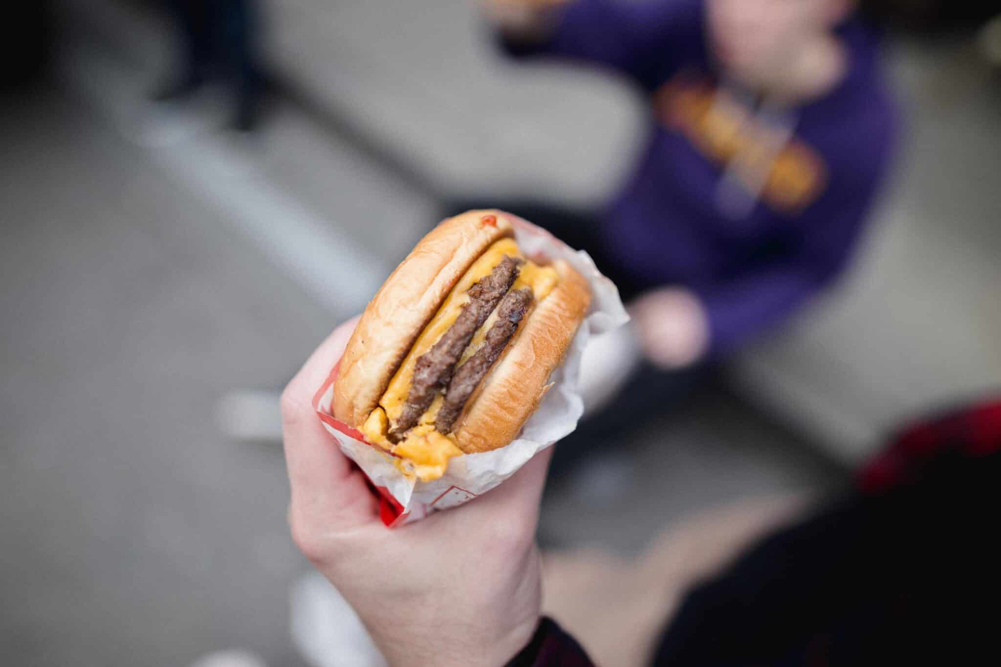 Cropped hand of person holding burger