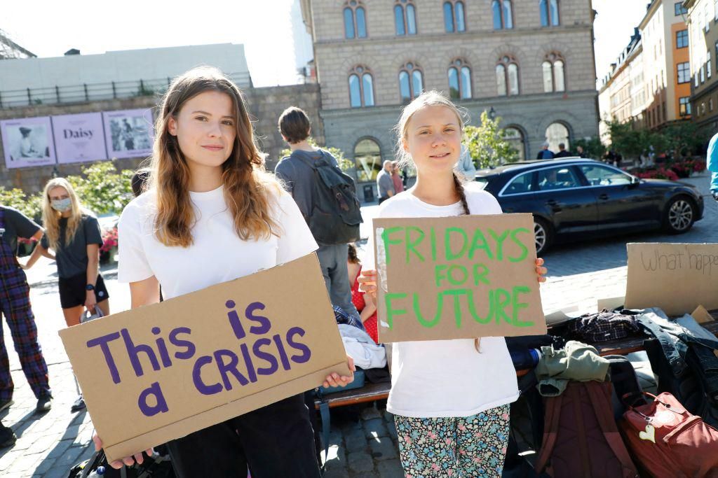 German climate activist Luisa Neubauer (L) and Swedish campaigner Greta Thunberg protest outside the Swedish Parliament.