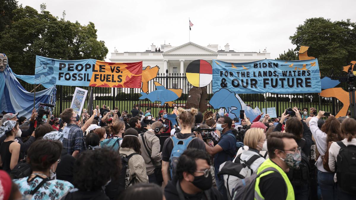 Demonstrators stand in front of the White House.