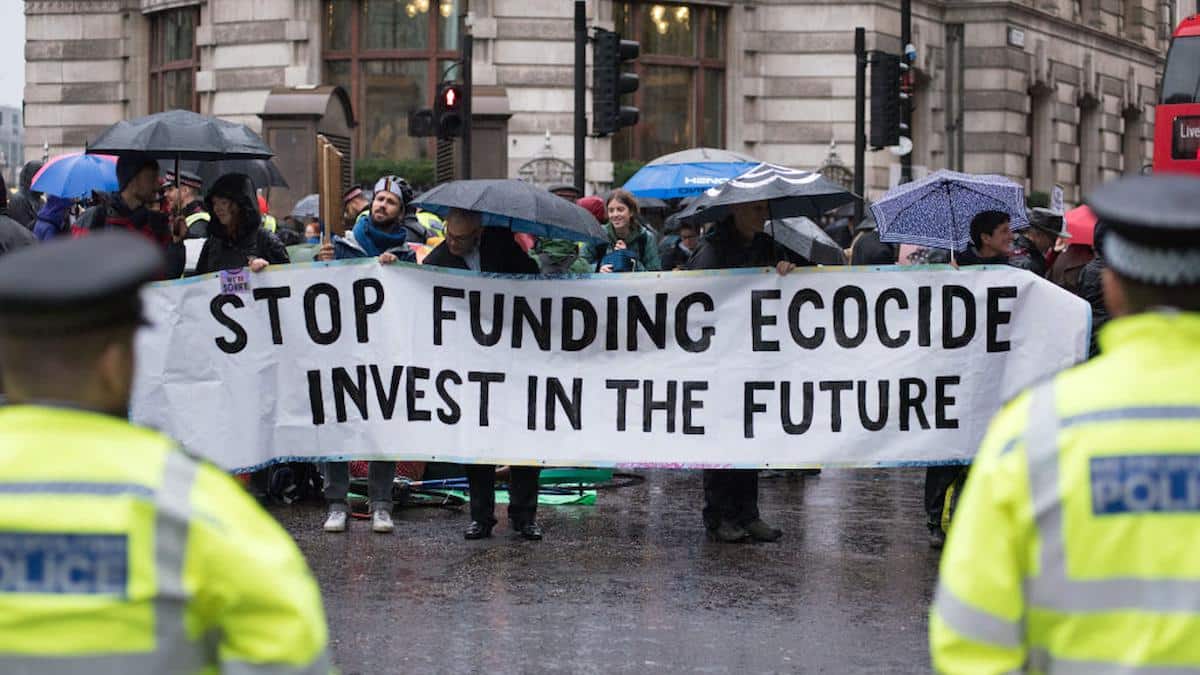 Protesters hold up a banner saying "Stop funding ecocide, invest in the future" outside the Bank of England on Oct. 14, 2019 in London, England.
