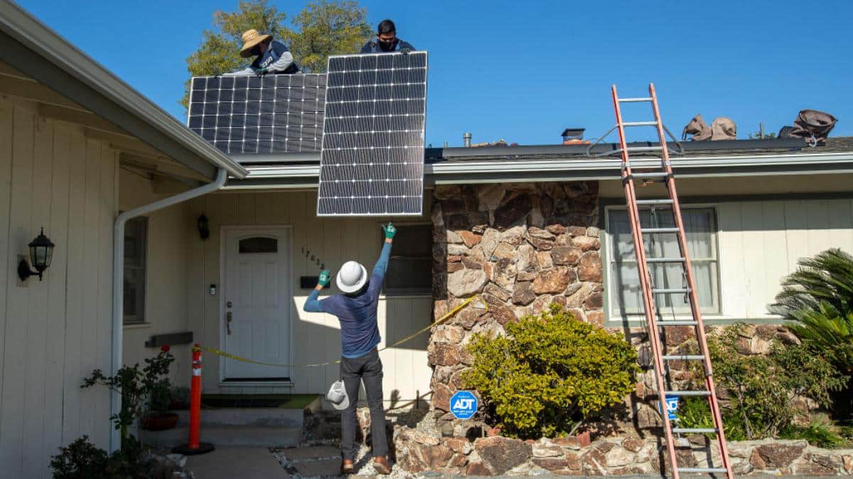 ​Solar workers install a rooftop system.