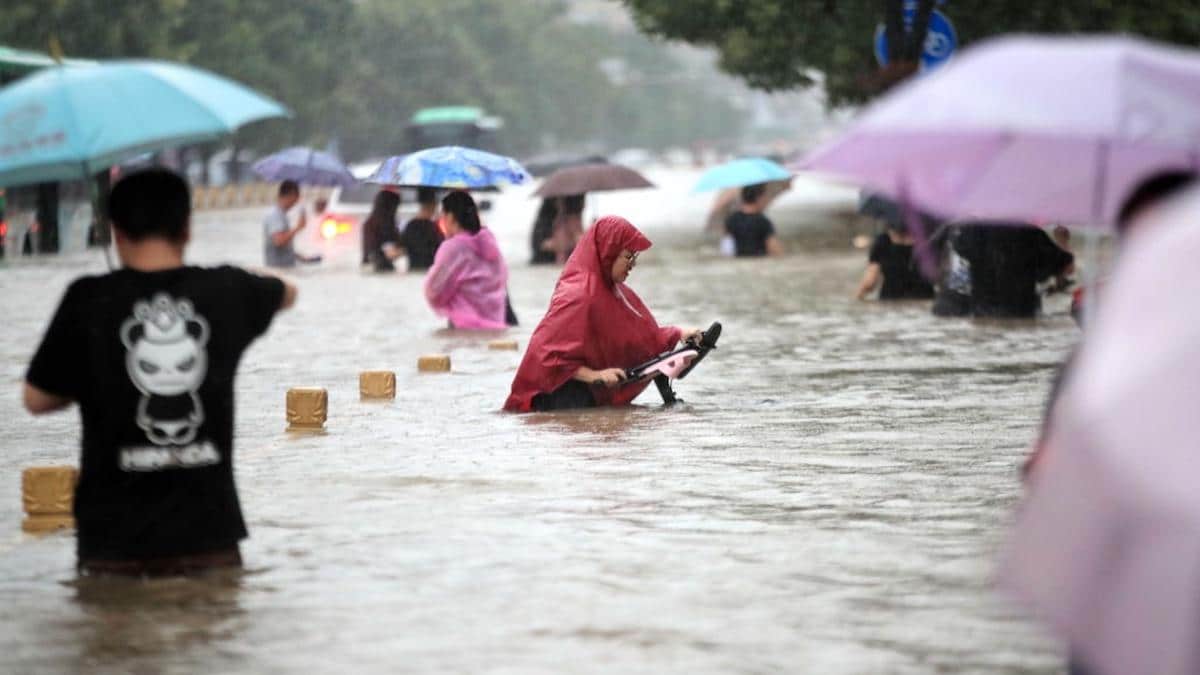 People walk in a flooded road in Zhengzhou city, China.