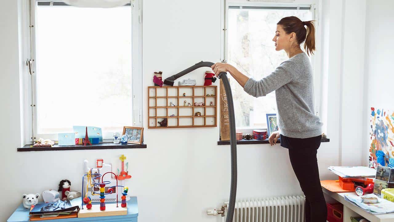 Woman vacuuming small shelves