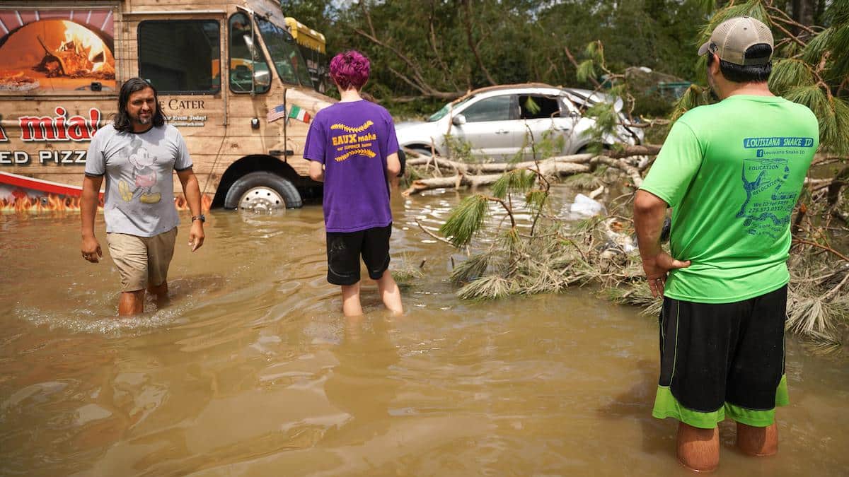 People wade through floodwaters from Hurricane Ida in Louisiana.