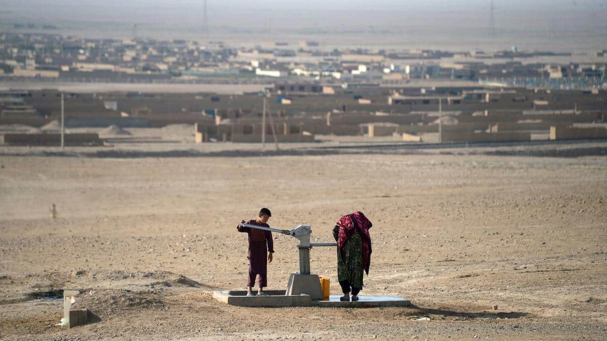 An Afghan boy uses a water pump to collect water during a drought.