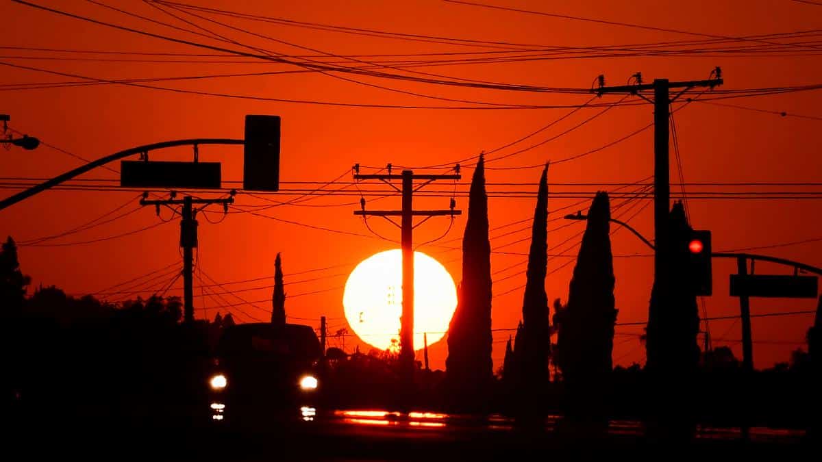 ​The sun sets behind power lines in Los Angeles, California before a heatwave.