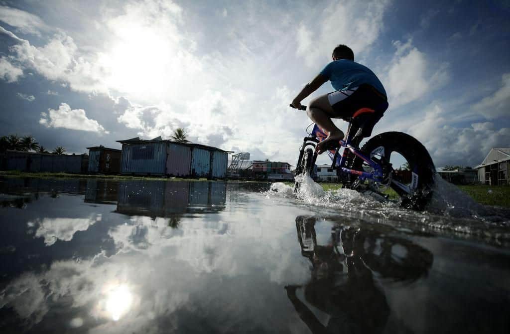 A boy rides his bike through floodwaters in Funafuti, Tuvalu.