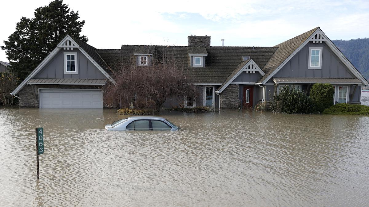 A home and car are submerged in floodwaters in British Columbia.