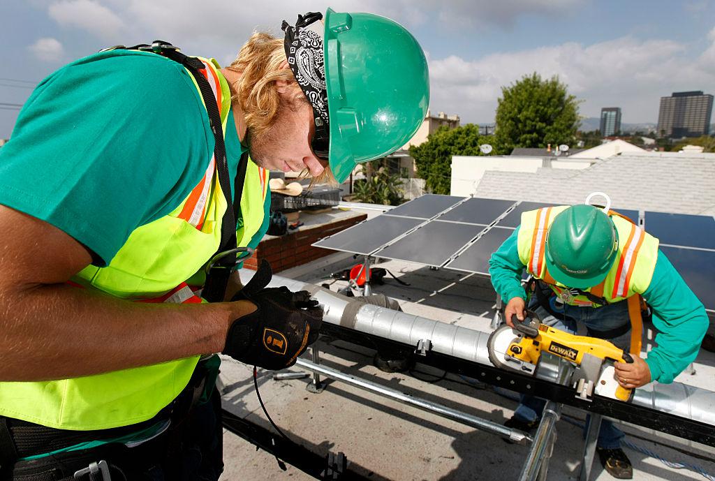 Workers install SolarCity panels in Los Angeles