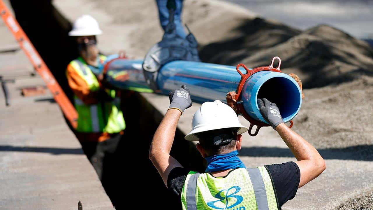 Workers install new water pipe