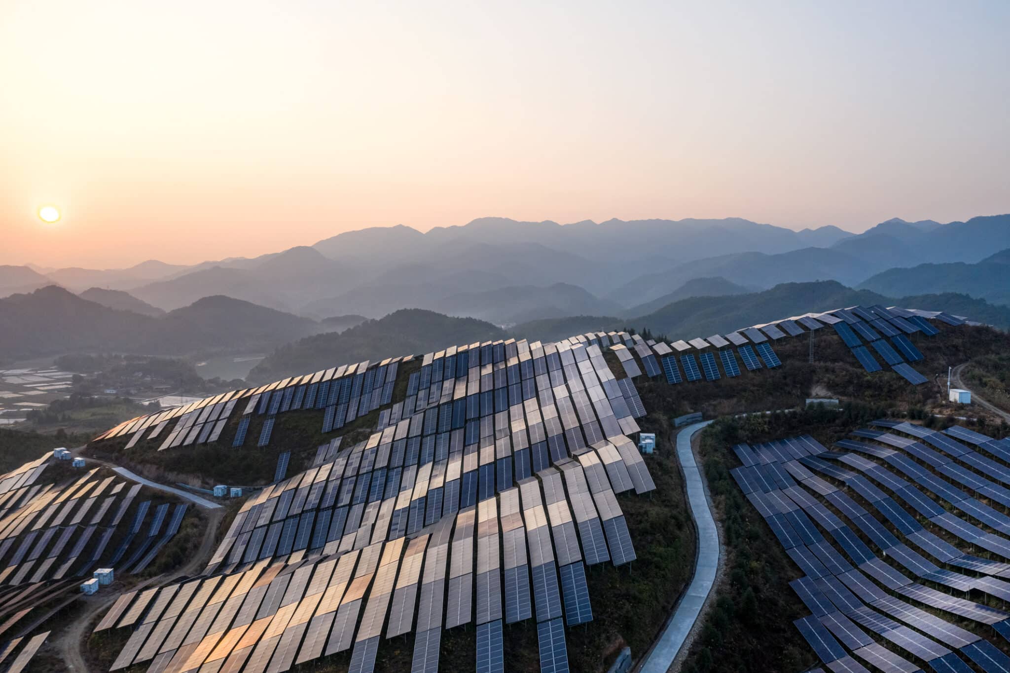 Aerial view of the solar power plant on the top of the mountain at sunset