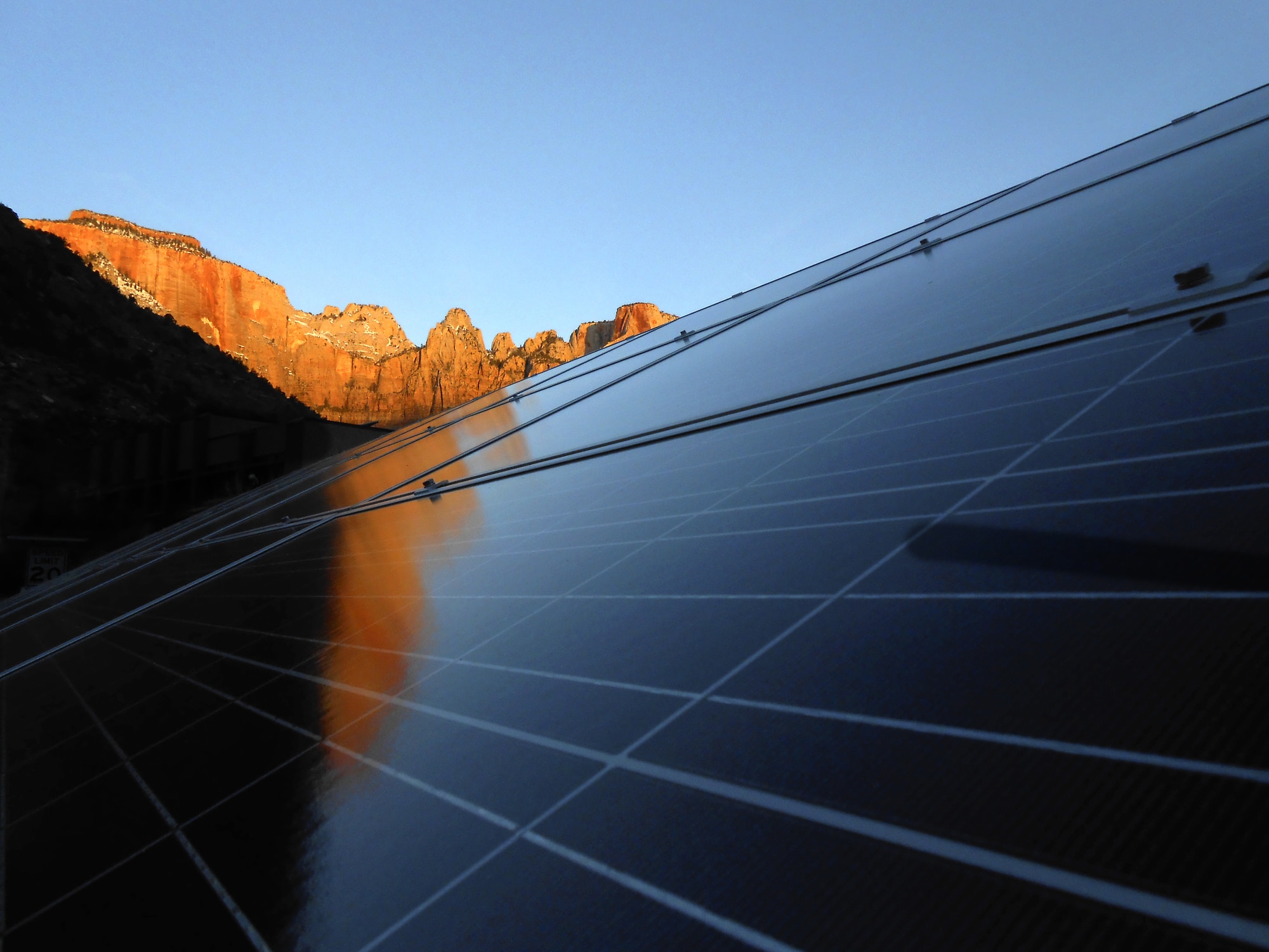 Solar Panels below Towers Of The Virgin with reflection at sunrise, Zion National Park, Utah