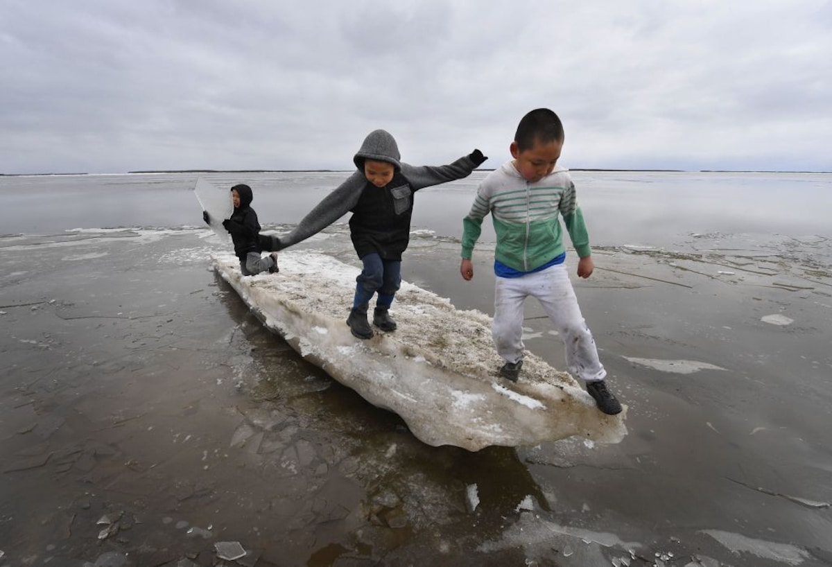 Native Alaskan children playing on melting ice.