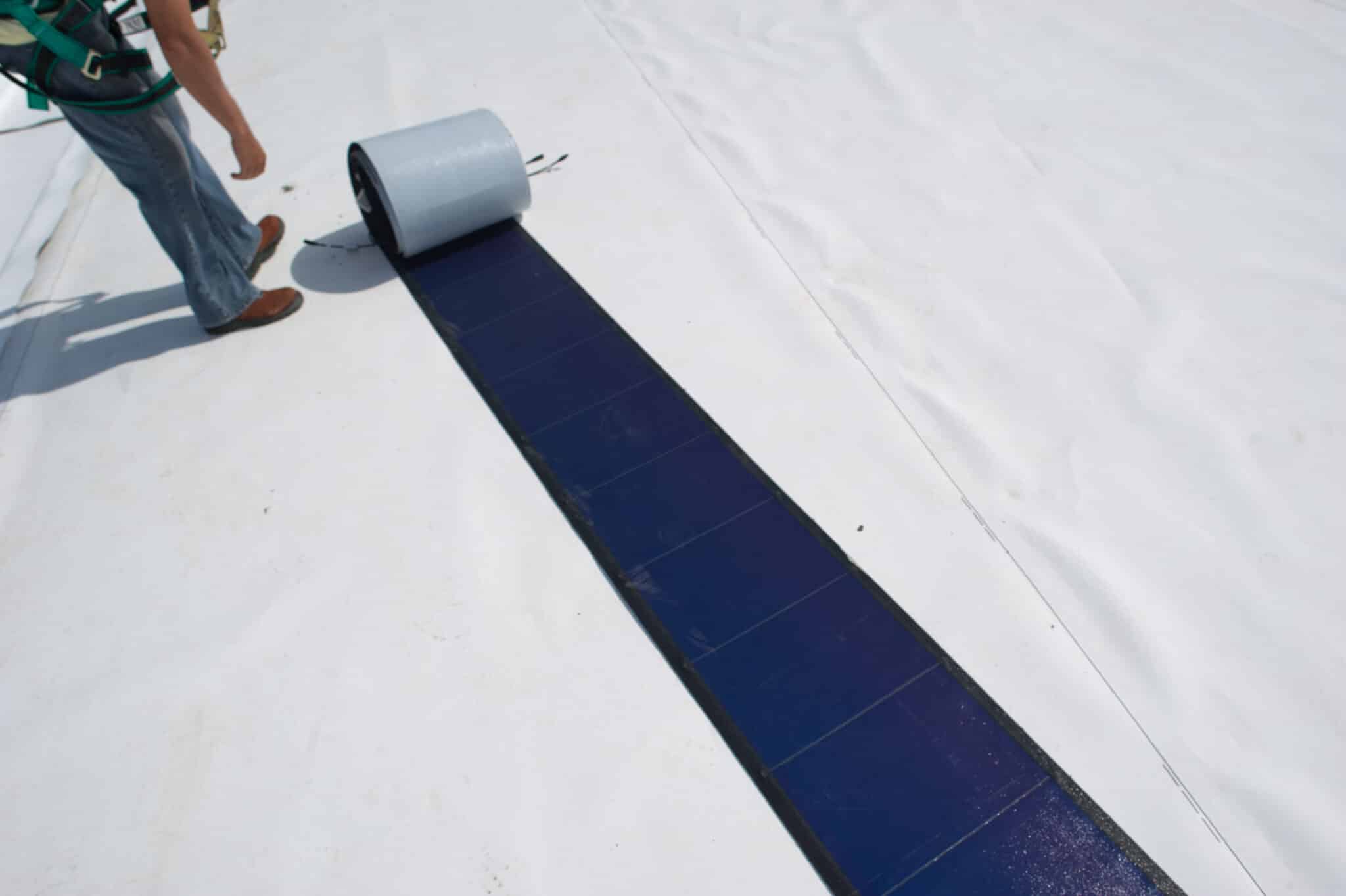 A worker deploys a flexible solar panel on the roof of the Pituacu stadium, in Salvador, Brazil on December 1, 2011. The Pituacu stadium will be the first sporting venue equipped with a photovoltaic system in Latin America.