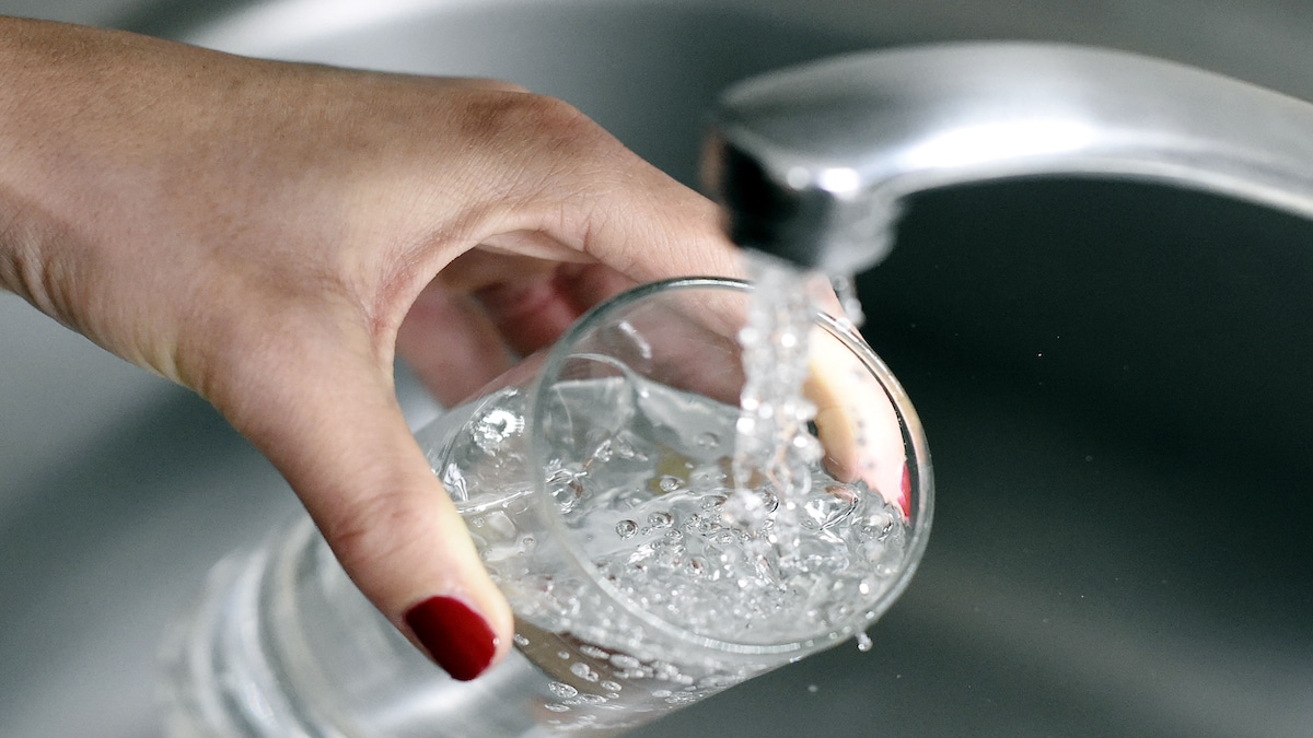 A woman fills up a glass with tap water