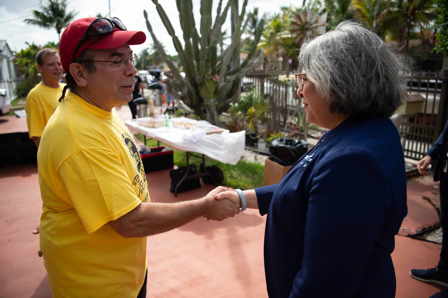 man with yellow shirt on shakes hand with female mayor of Miami-Dade county
