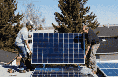 two men transporting a solar panel