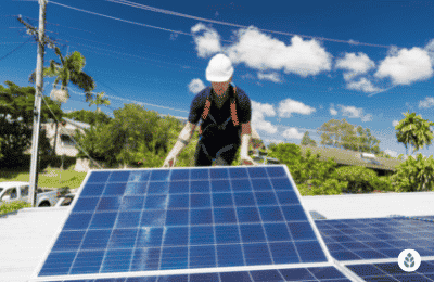 man installing solar panels on a house roof