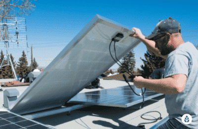 man checking underneath a solar panel