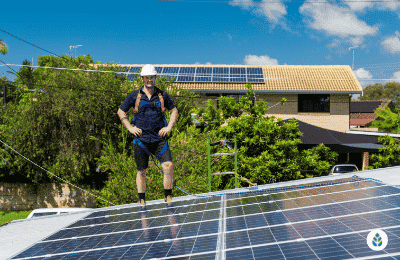 man looking at solar panels on the roof