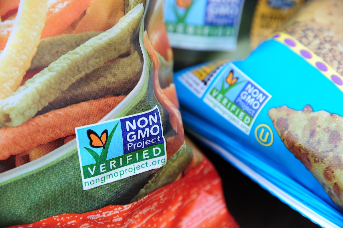 Labels on bags of snack foods indicate they are non-GMO food products