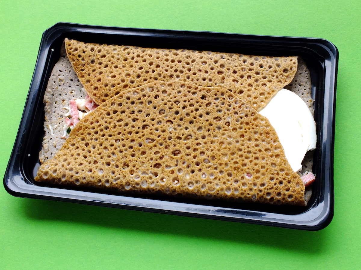 A buckwheat pancake breakfast on a plastic tray.