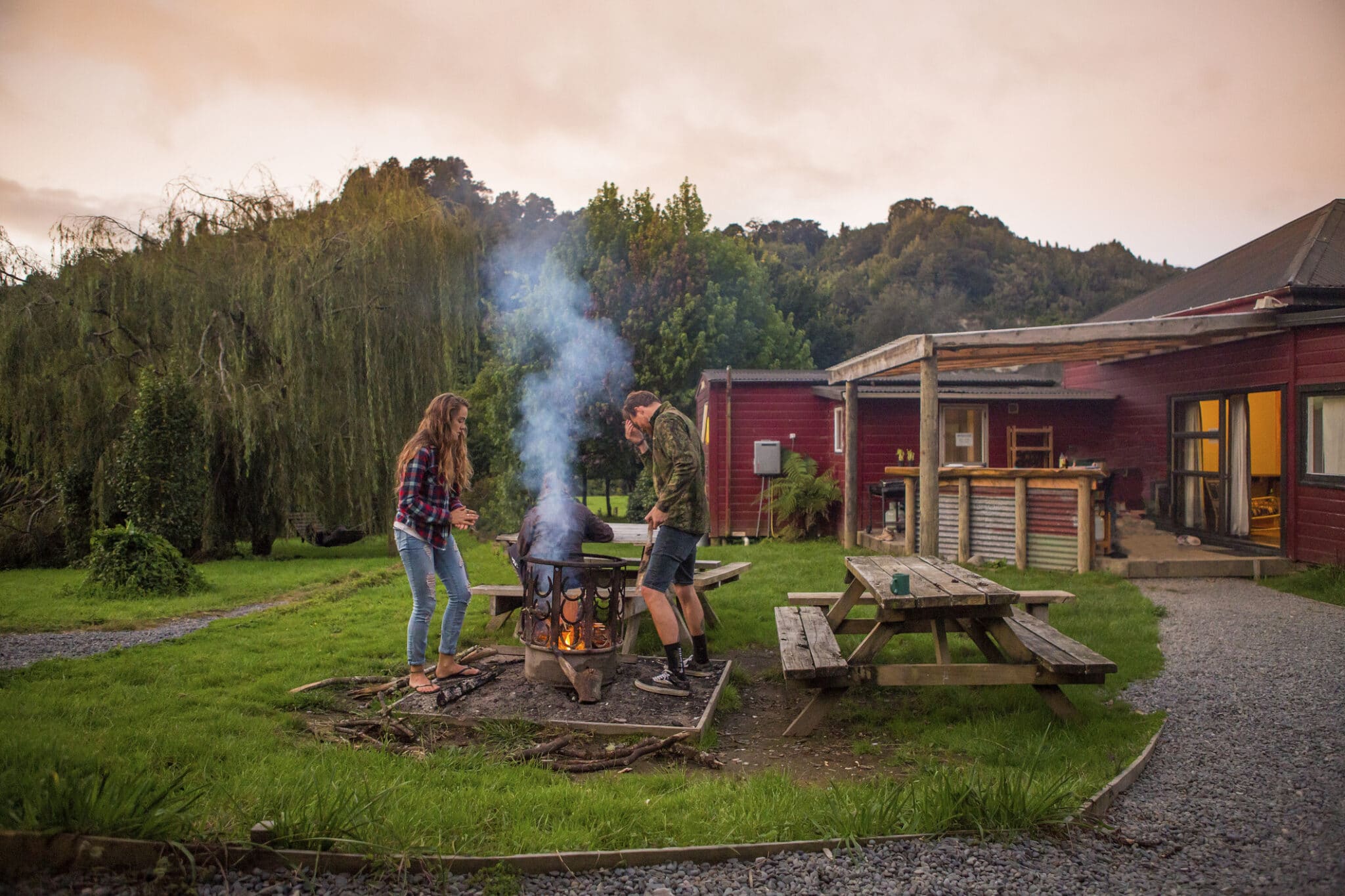 A couple starts a bonfire at the campsite.