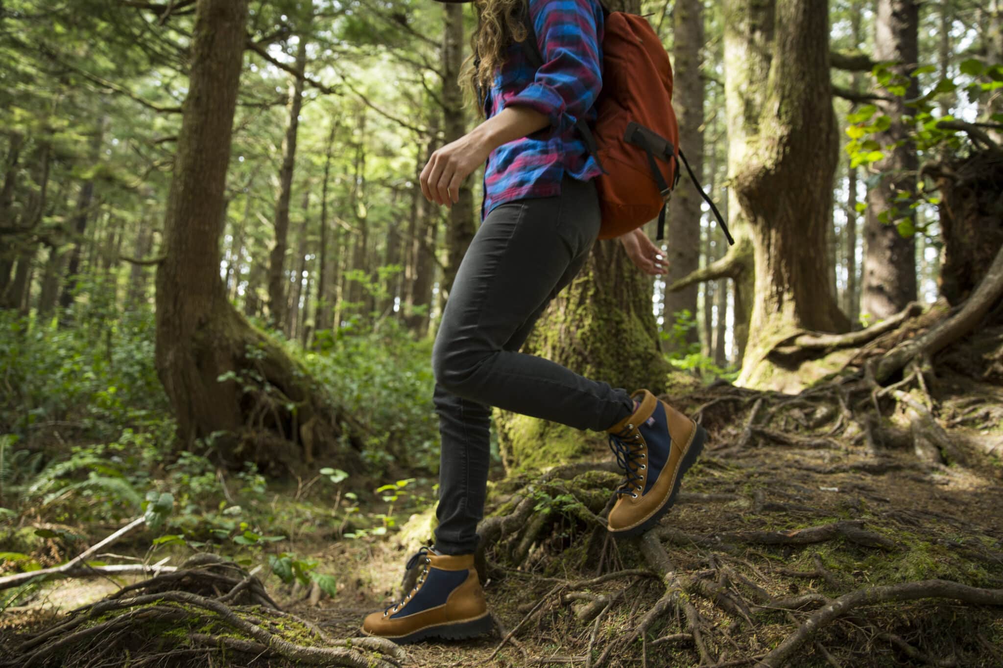 A woman hiking in a dense forest.
