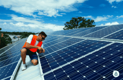 man with an orange vest checking solar panels