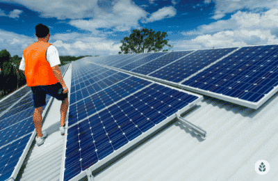 man in orange vest checking a solar panel installation