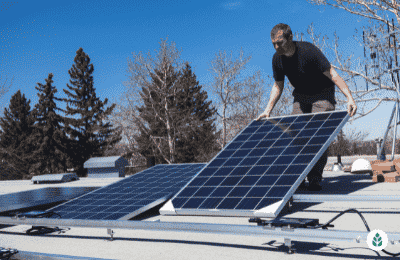 man lowering a solar panel for installation