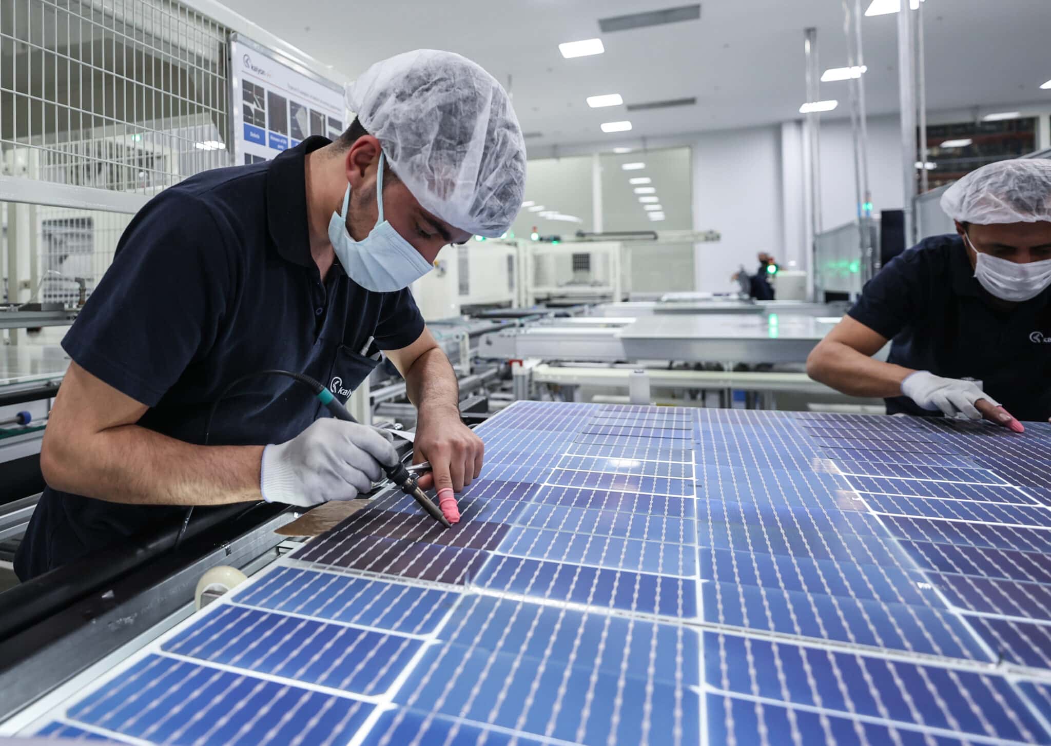 Solar panel production facility with worker working on solar panel manufacturing