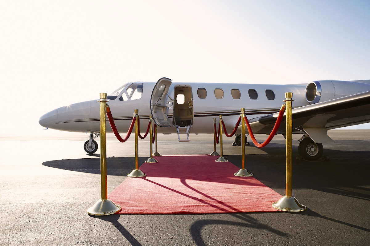 A luxurious private airplane with a red carpet leading up to it