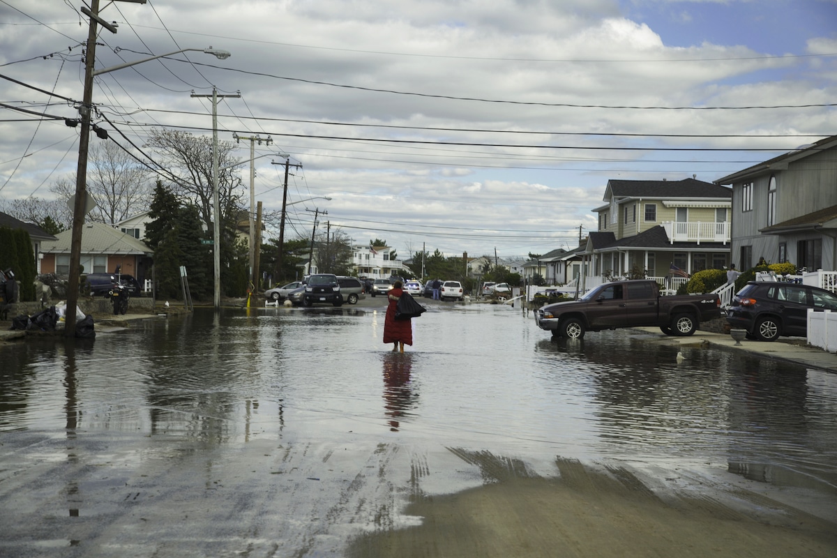 A woman stands in a flooded neighborhood following Hurricane Sandy