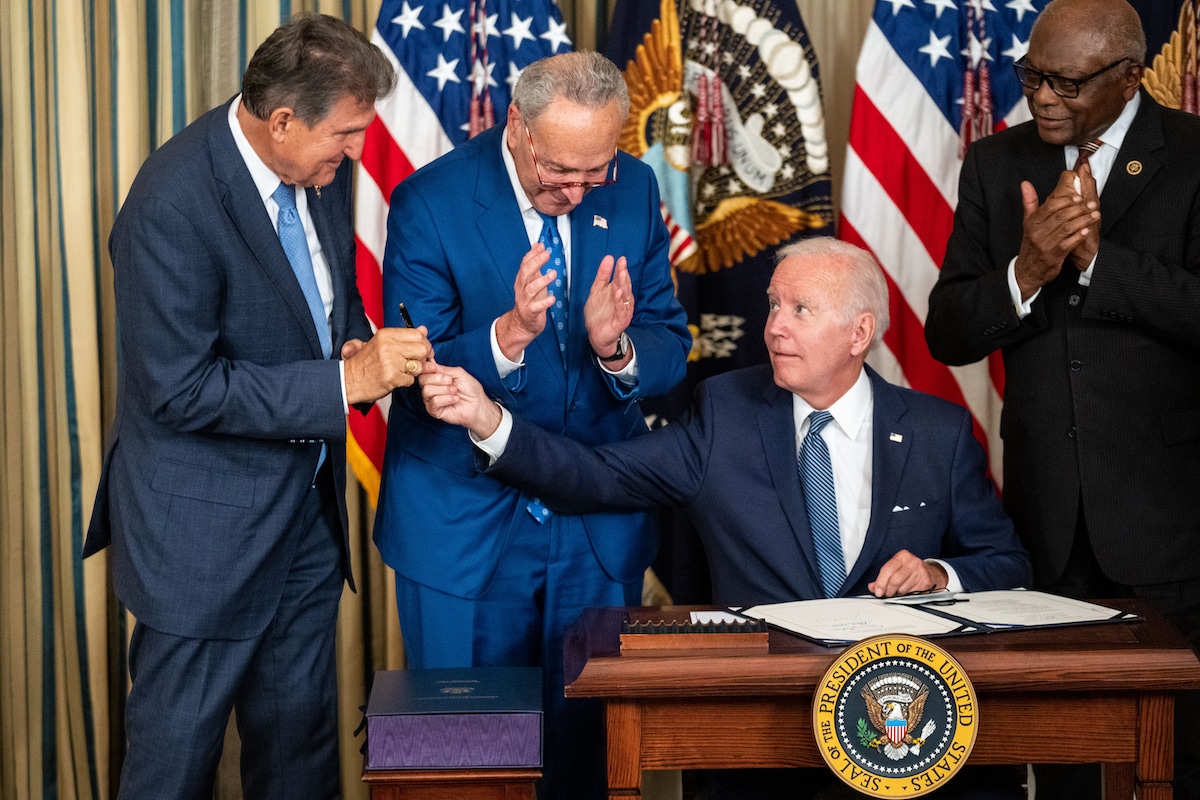 President Joe Biden hands the pen used to sign the Inflation Reduction Act to Sen. Joe Manchin