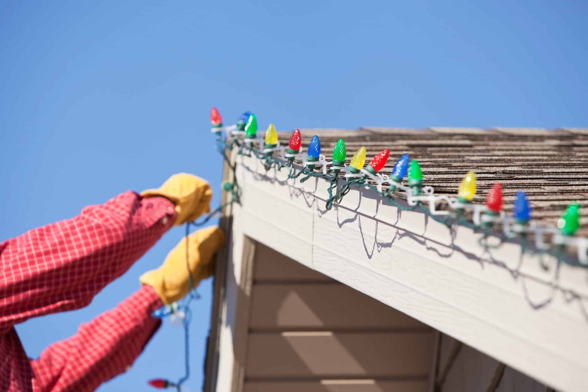 homeowner safely puts up Christmas lights without damaging their roof