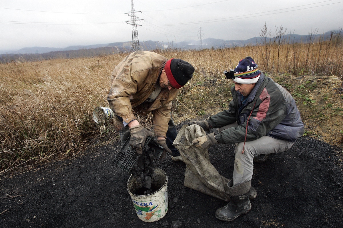 Two people mine coal illegally in a field in Walbrzych, Poland