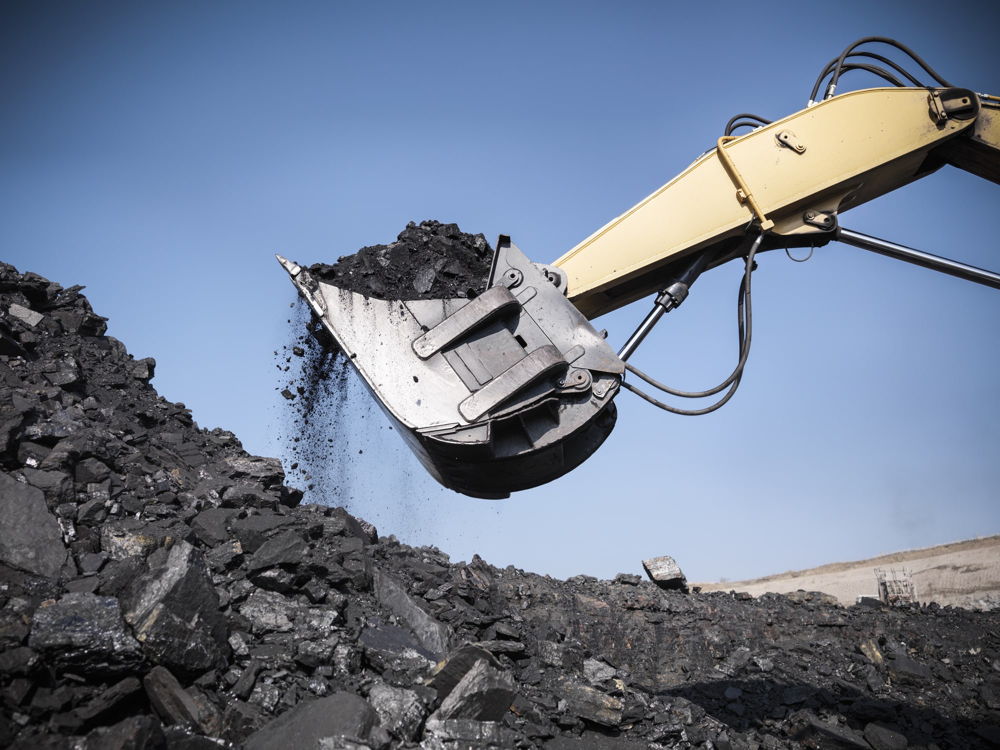 Digger lifting coal from opencast coalmine