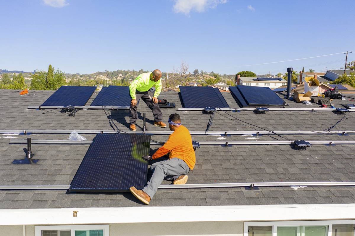 A team of workers installs solar panels on a home in Southern California