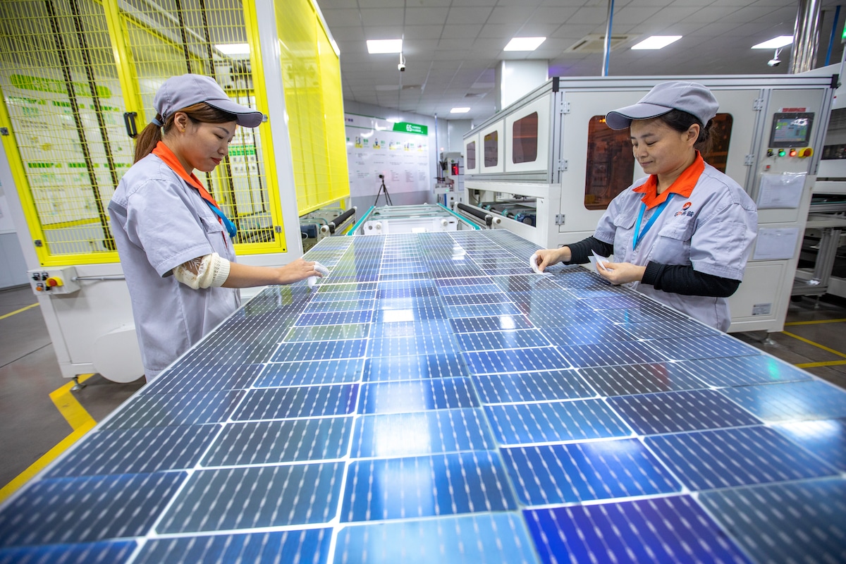 Employees work on a solar panel production line at a factory in China