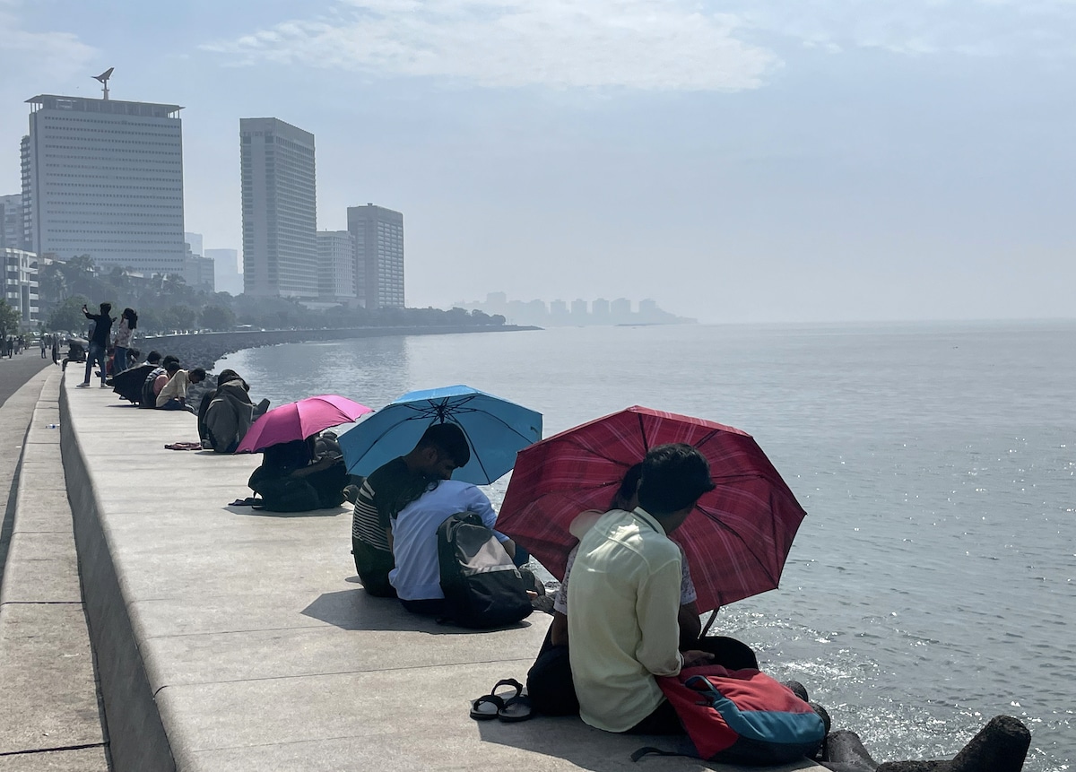 People use umbrellas to shield themselves from the sun on a hot day in Mumbai, India