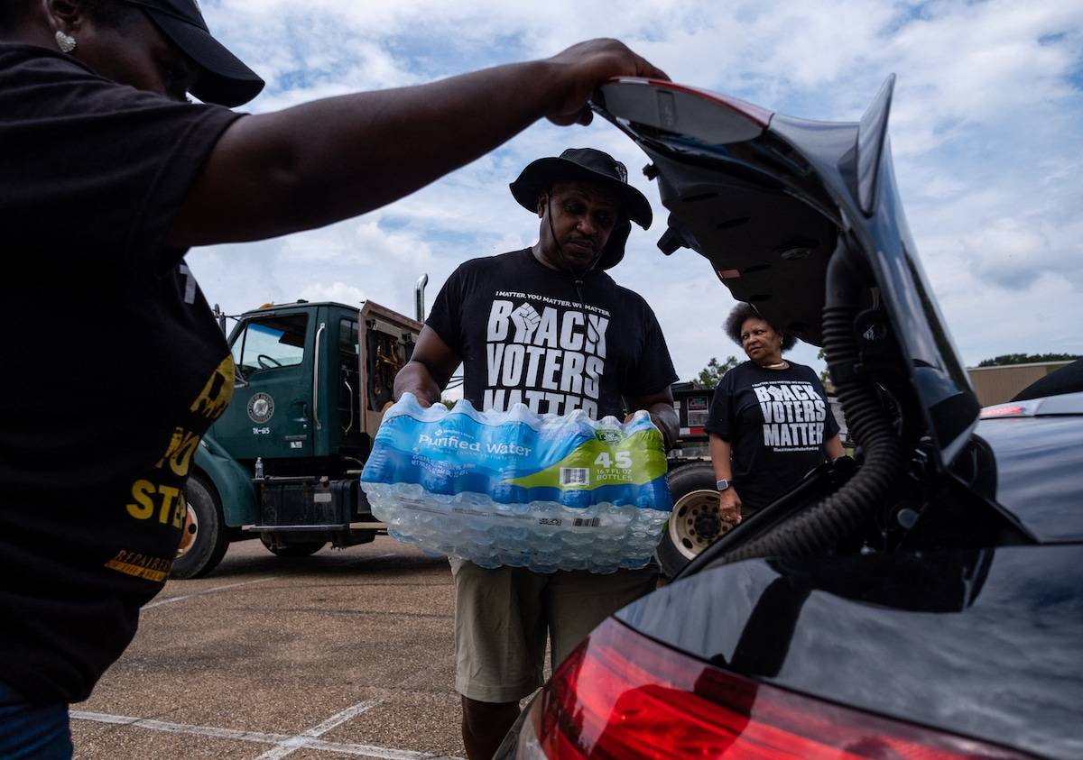 Residents distribute cases of water at Grove Park Community Center in Jackson, Mississippi