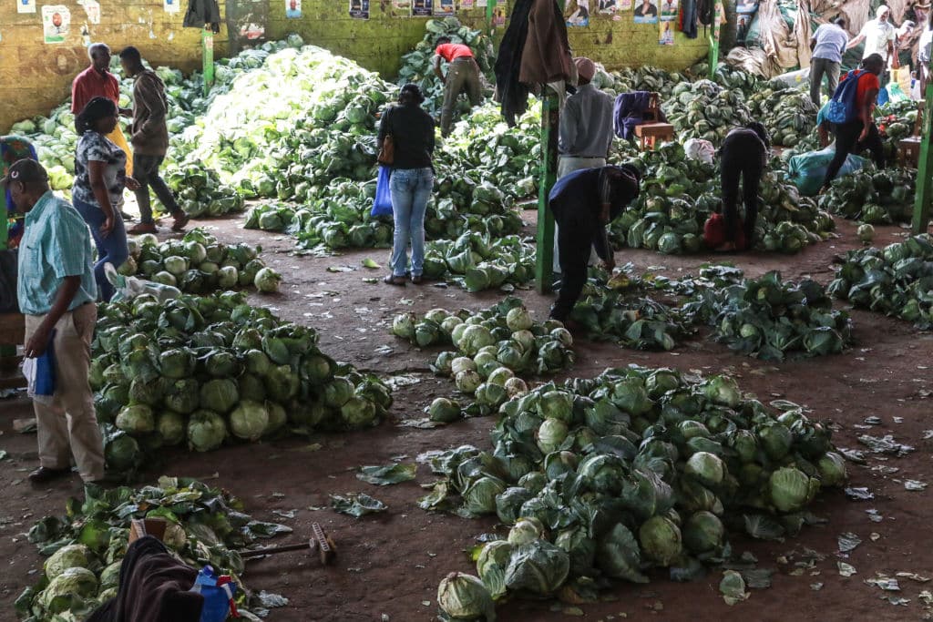 People buy vegetables at a wholesale market on Christmas Eve